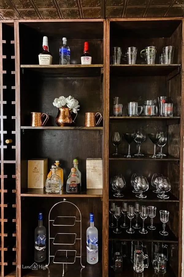 This shows the wine cellar shelves on the far right holding all the stem ware and some liquor bottles.
