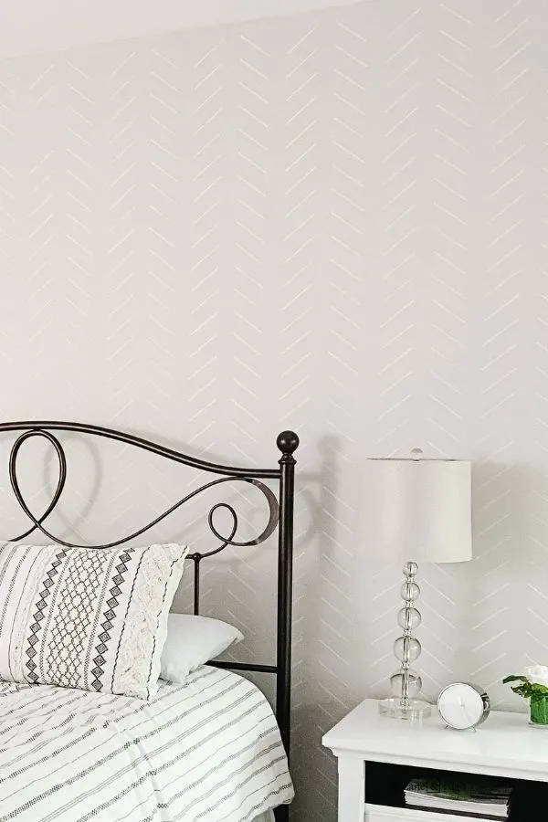 A headboard wall with herringbone stencil done in white.