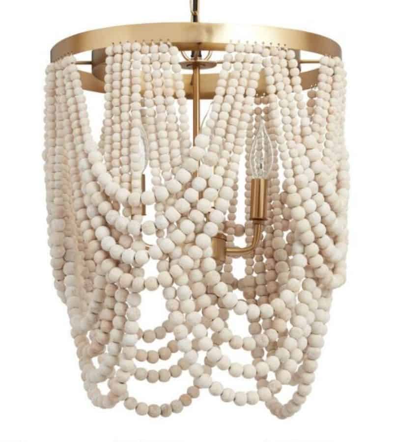 A white beaded drapey chandelier with gold metal.