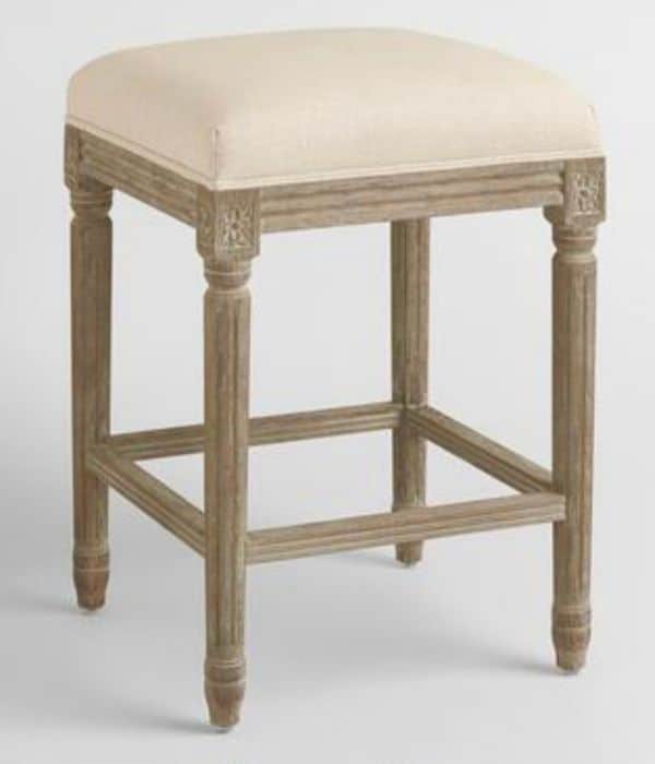 Brownish Gray distressed wood stool with a light beige linen seat that has no back.