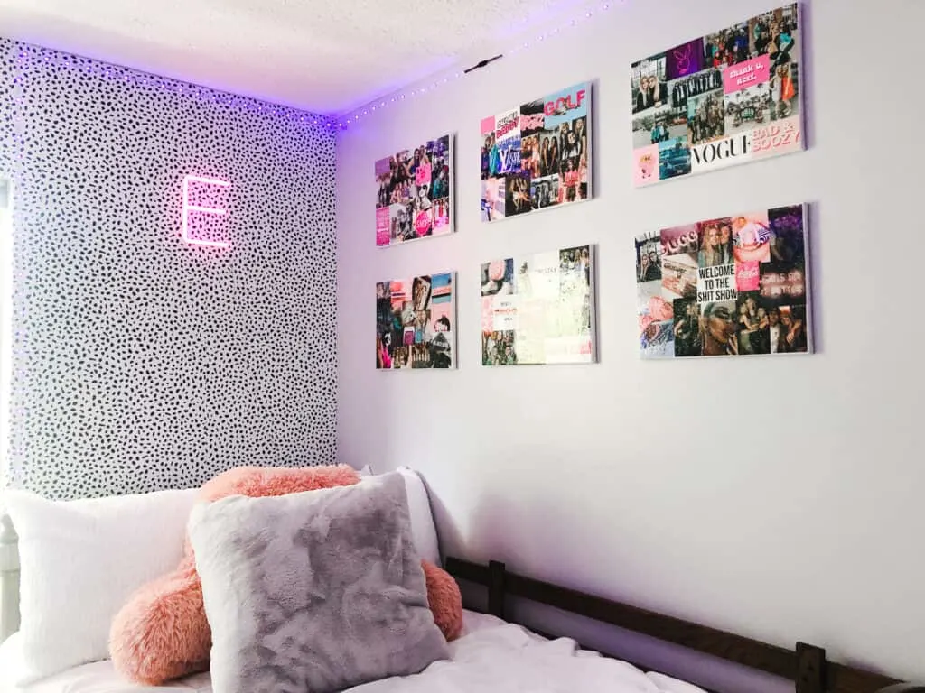 This is my daughters corner of her room above her bed with leopard print wallpaper, a neon sign with an E and the gallery wall of canvases.