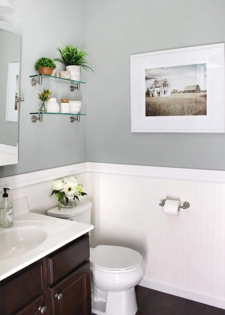 A powder room with white wainscoting on the bottom half of the walls and Oyster Bay painted on the top half.