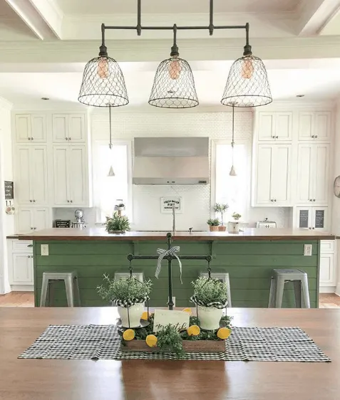 A kitchen where the island is painted Sherwin Williams Basil and the rest of the cabinetry is a creamy white.