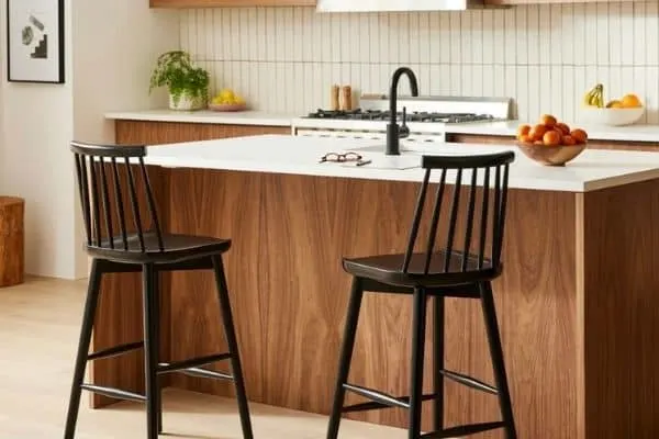 High backed wooden bar stools that have spindles for a back and are painted black.
