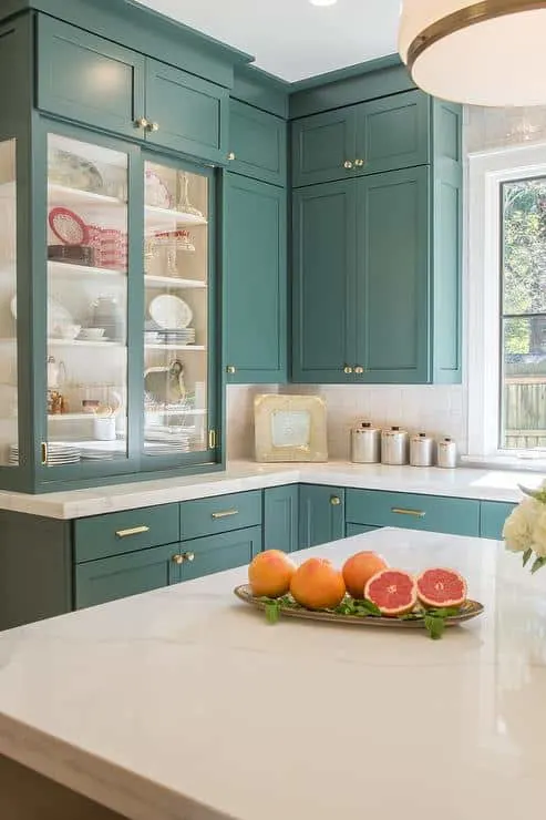 Tarrytown Green on wall cabinets with gold hardware and white marble cabinets.