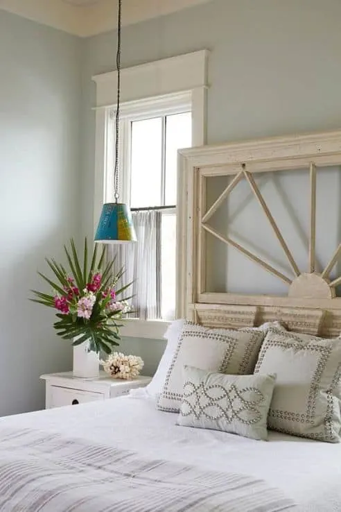A bedroom with white trim around the windows and Tranquility painted on the walls.