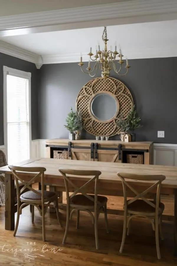 Benjamin Moore Kendal Charcoal paint on the top two thirds of the walls in a dining room with white wainscoting and wood furniture.