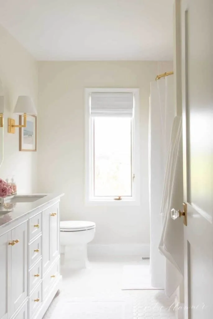 White Dove on cabinets and trim in a bathroom with very light walls and white tile floor.