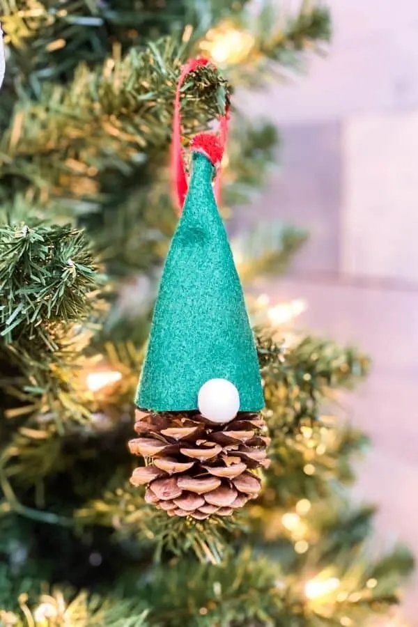 The finished ornament with a green felt had, red pompom top and hanging on the Christmas tree.