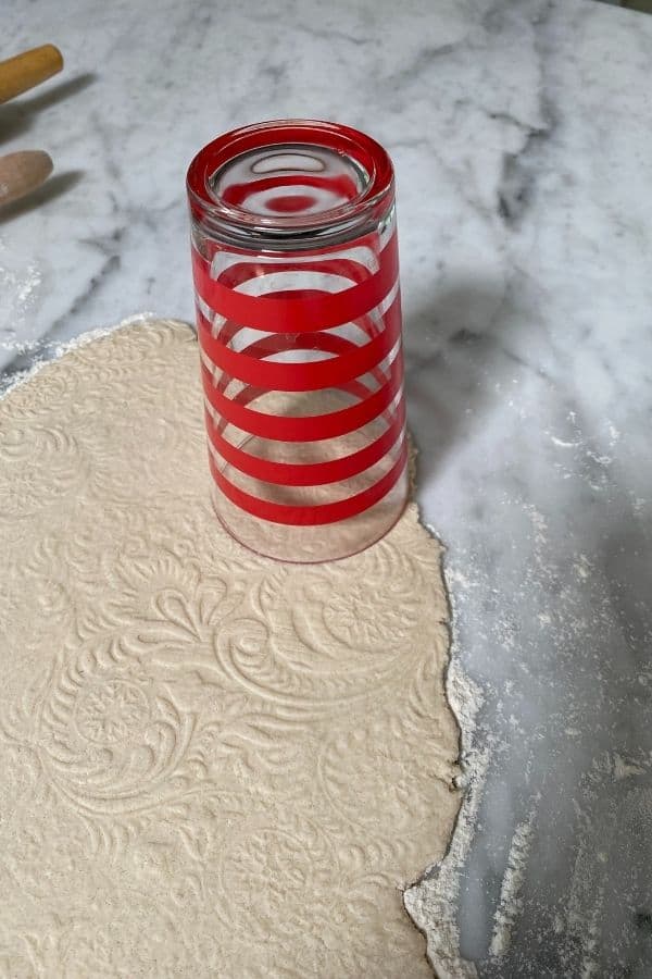Using a glass to cut out circles in my salt dough to make ornaments.