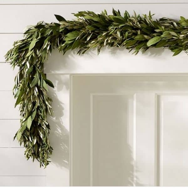 An olive branch garland hung above a doorway and white shiplap on the walls.