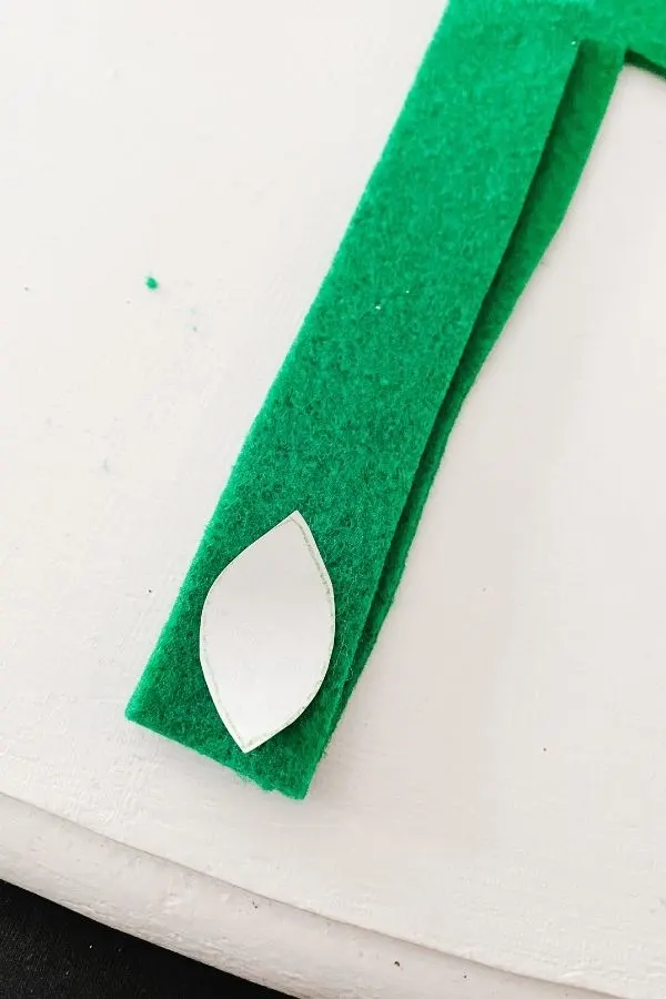 The leaf on two pieces of green felt in preparation of cutting out via the template.
