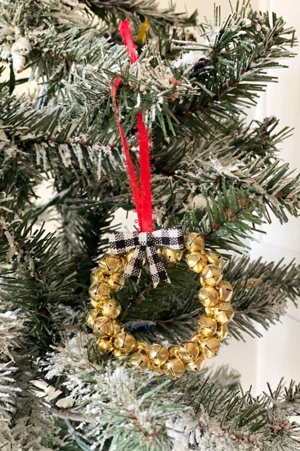 The jingle bell ornament hanging from a Christmas tree.