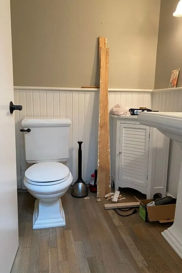 My powder room with the baseboards off and tools all over the floor.