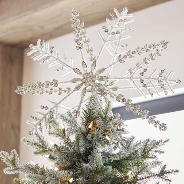 A silver jeweled snowflake shaped Christmas tree topper.