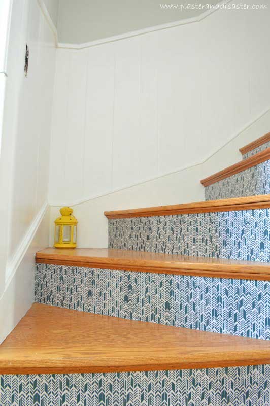 Blue and white fabric adhered to stair risers in a chevron pattern.