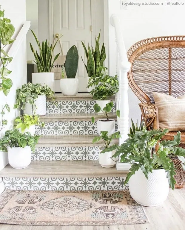 Gray and white stenciled stairs with tons of plants in white pots on them.