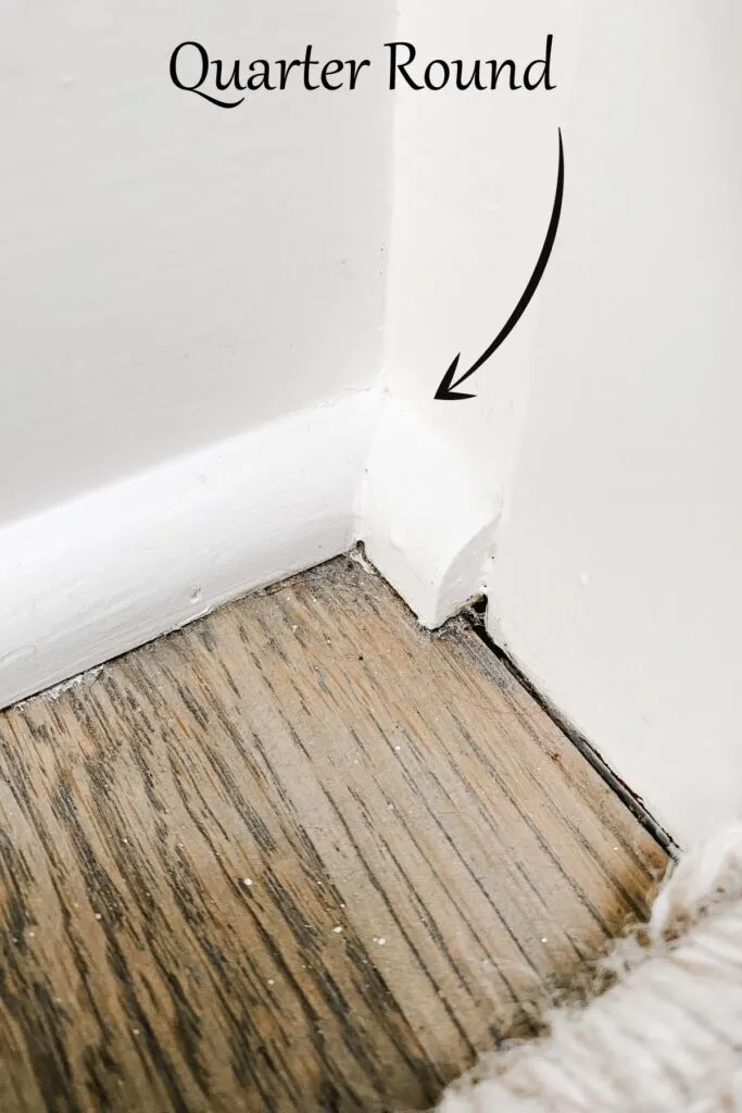 this shows white quarter round at the base of white painted baseboards agains my wood floors.