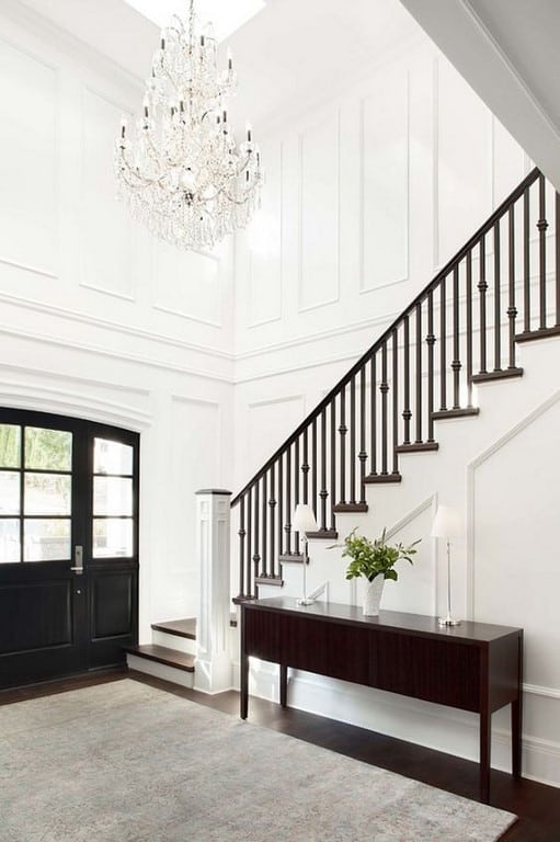 A staircase with white walls and picture molding with vaulted ceilings.