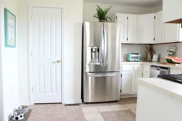 This is a kitchen with stainless steel appliances and cabinets panted Dover White by Sherwin Williams.