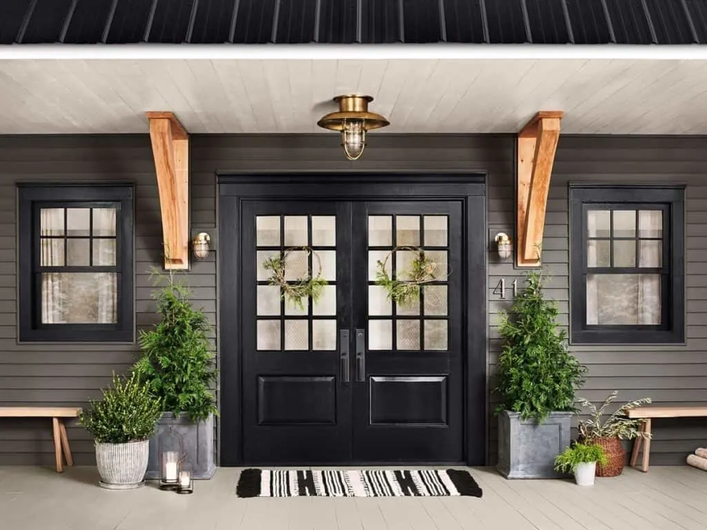 Urbane Bronze used on front doors with a black and white rug, greenery flanking the doors and a bronze light fixture.