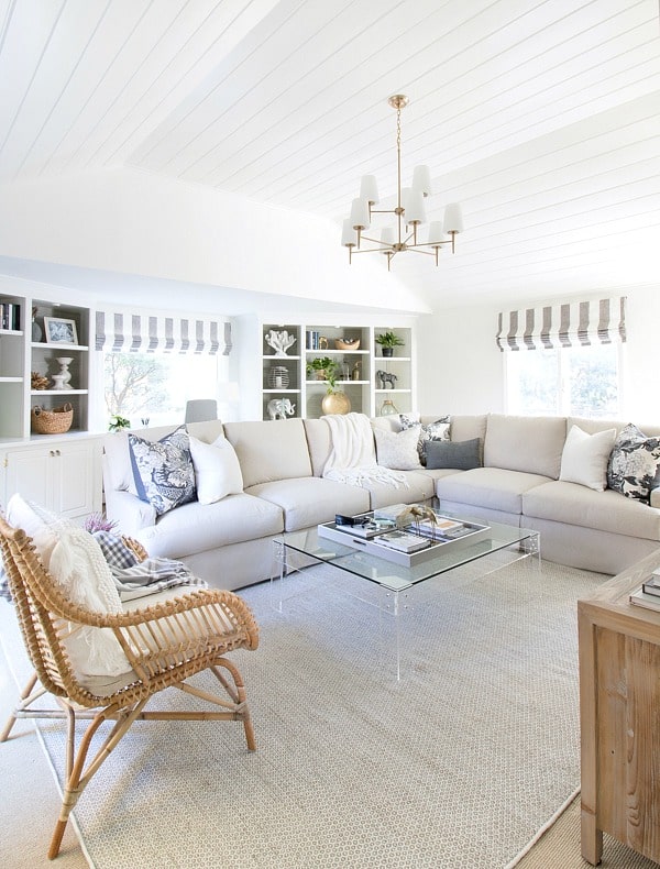 A family room with the walls and built-ons in Benjamin Moore Cloud White with neutral furniture.