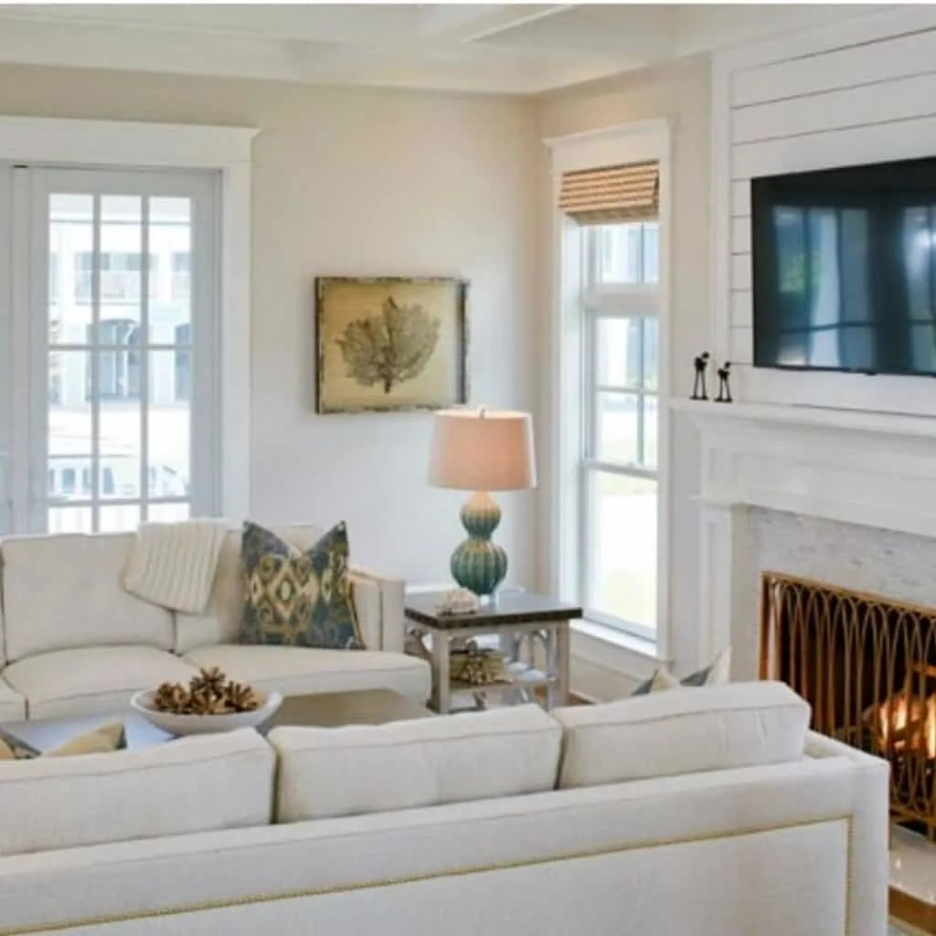 A family room with cream sofas, shiplap on the fireplace and Balboa Mist on the walls.