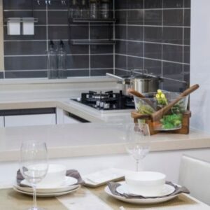 A kitchen with a table set and gray subway tile with beige countertops.