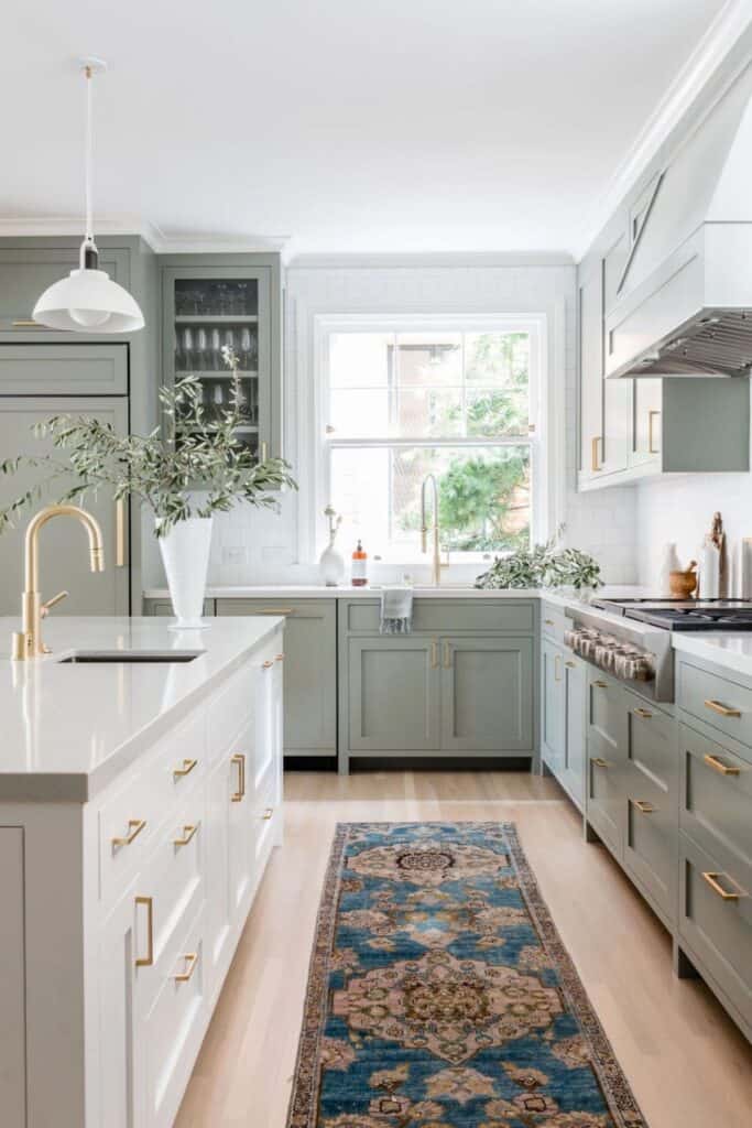 Gray cabinets with gold hardware, a runner on light hardwood floors.