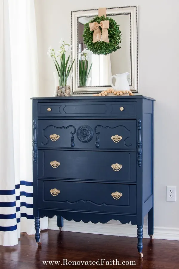 A dresser painted with Hale Navy and has gold pulls.