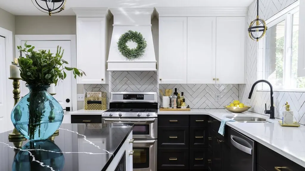 Black lower cabinets and white uppers with a white subway tile backsplash in a herringbone pattern.