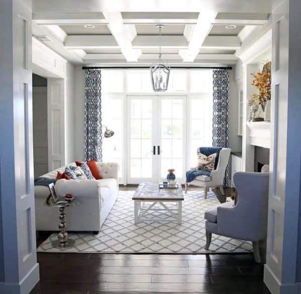 A family room with dark hardwood floors, a white coffered ceiling with gray on the ceiling panels.