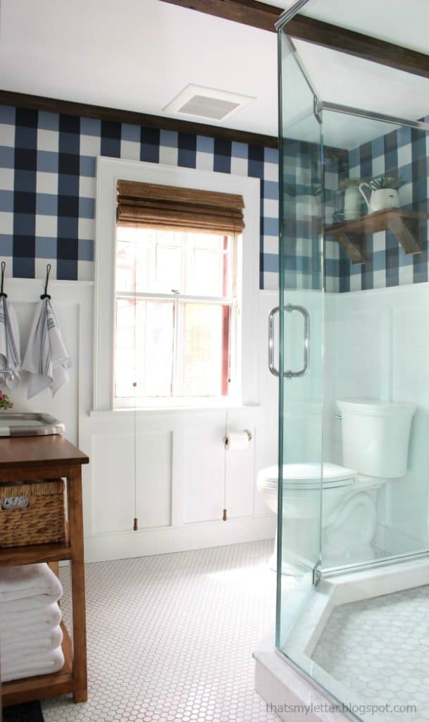 A bathroom with white board and batten and a plaid pattern above with hale navy.