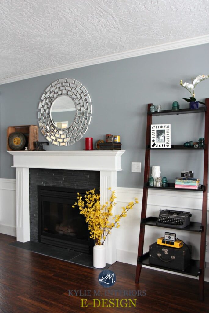 A family room with Network Gray on the walls with white wainscoting and a white fireplace mantel and dark hardwood floors.