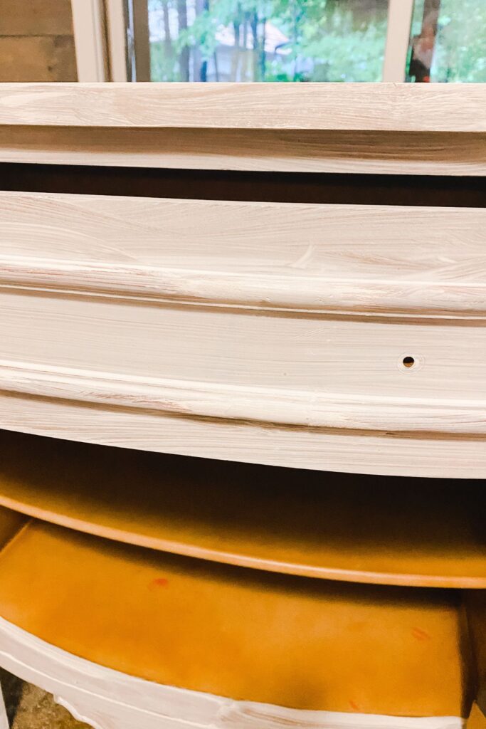 the drawer of a cabinet after bondo was attached to a chip and the piece has been primed.