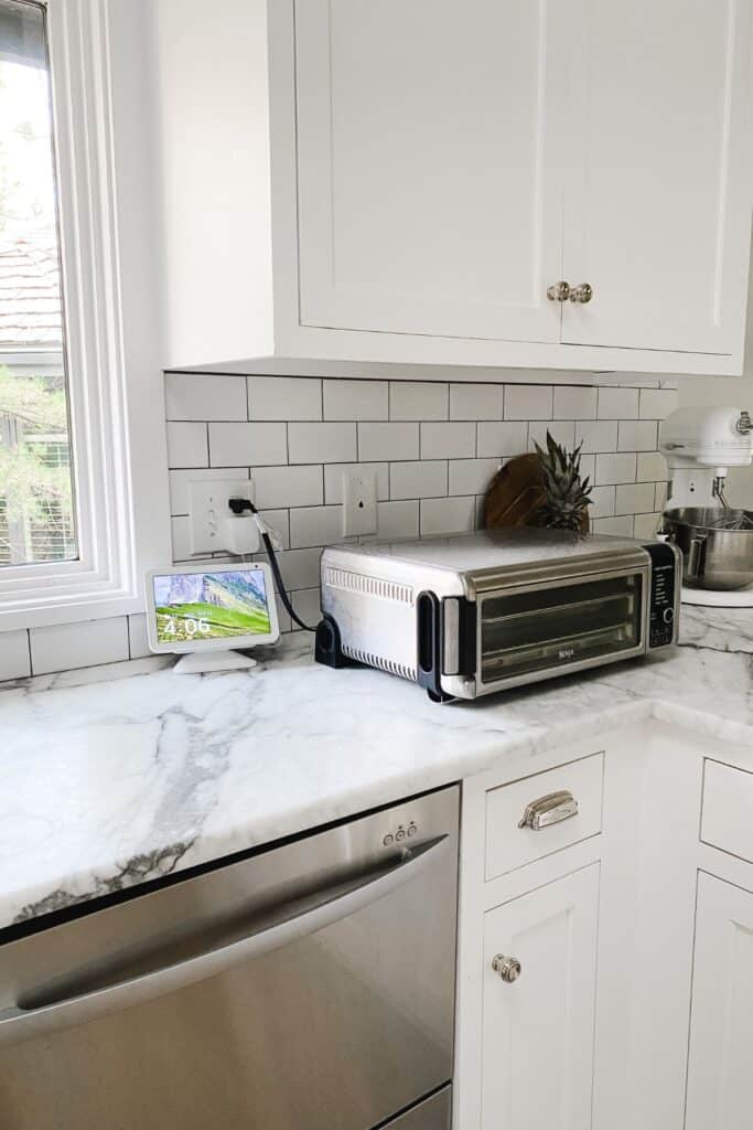 White kitchen with a subway tile backsplash and dark gray grout.