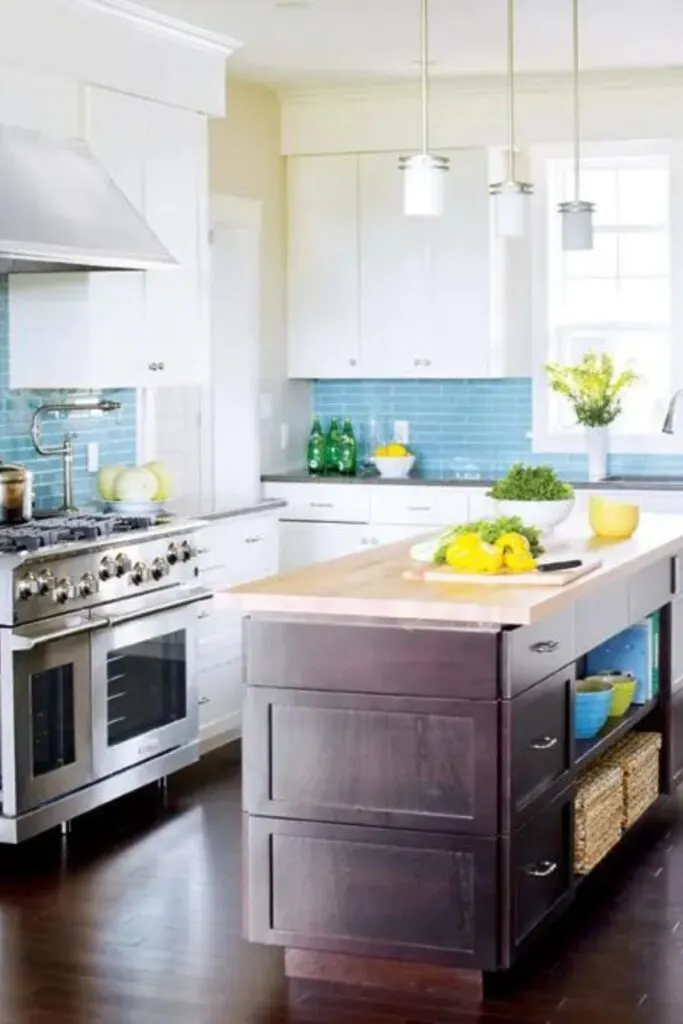 white kitchen with light blue subway tile in a staggered brick pattern and gray countertops.