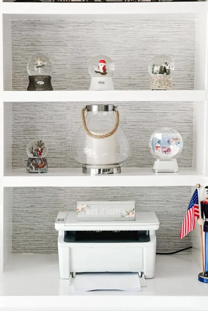 A snow globe collection on the shelves above my printer.