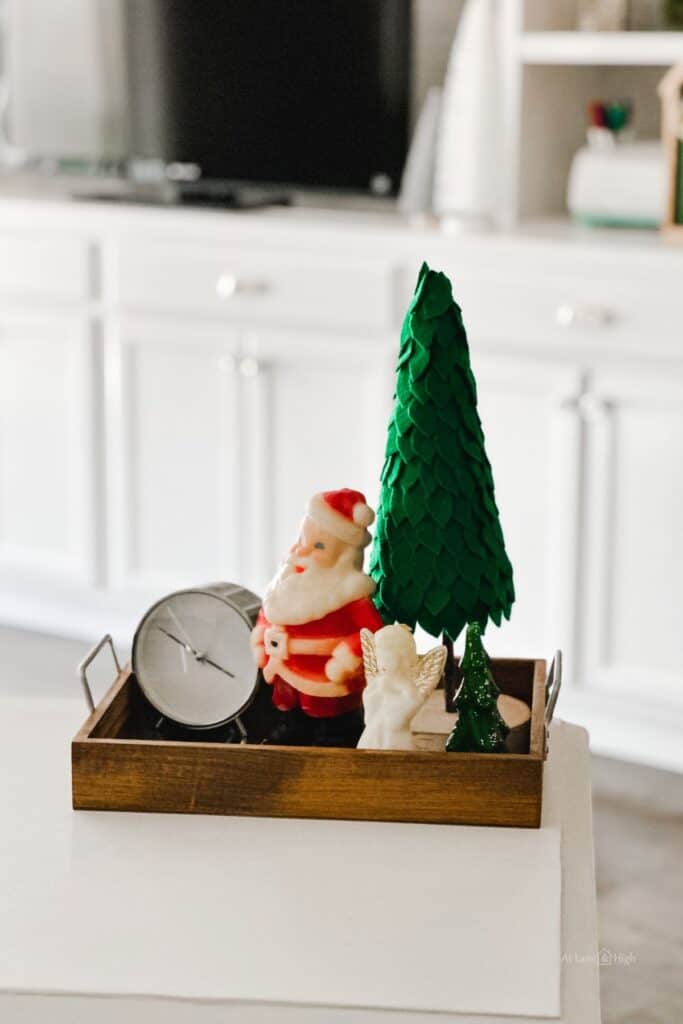 A vignette on my desk of a felt Christmas tree, a santa and angel candle and a clock.