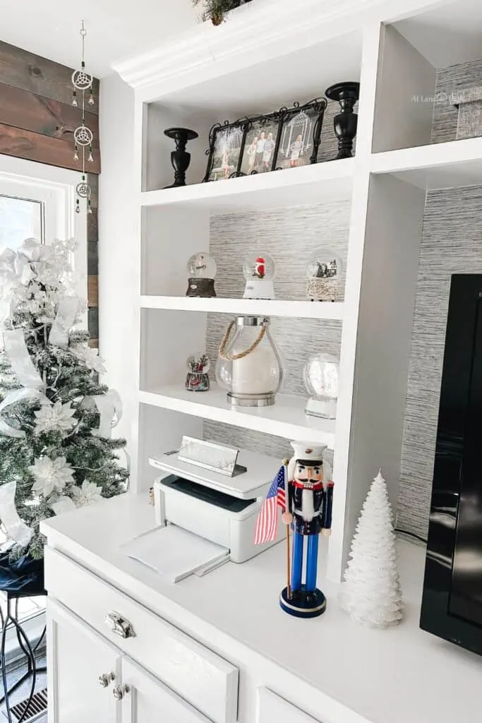 A view of my built-ins with my daughters snow globe collections, a Marine Corps nutcracker and a flocked Christmas tree with white ribbon.