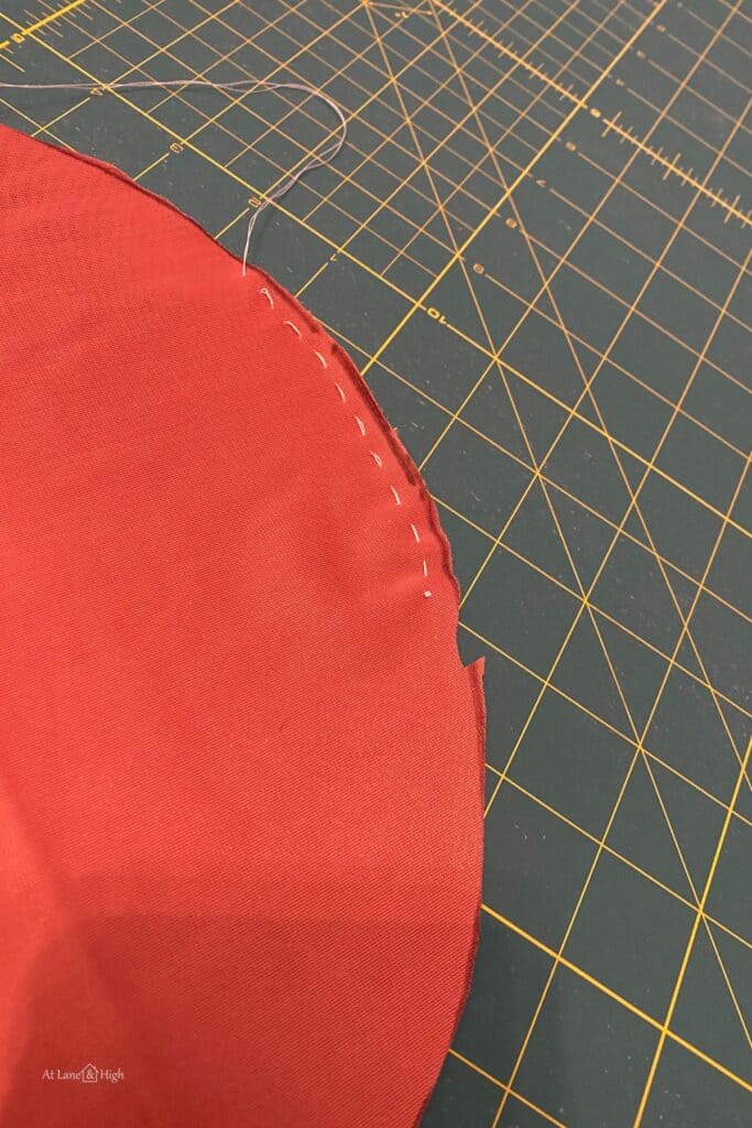 The stitching on the edges of the cut out circle of velvet.
