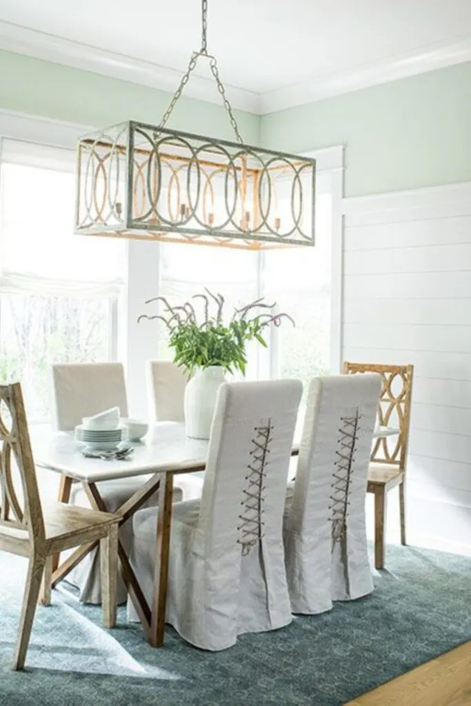 A dining room with shiplap on 2/3 of the walls and Hollingsworth Green painted above.