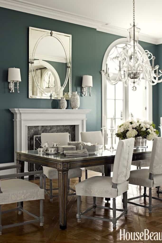 A formal dining room with Night Train on the walls, lots of white and siver with a huge chandelier.