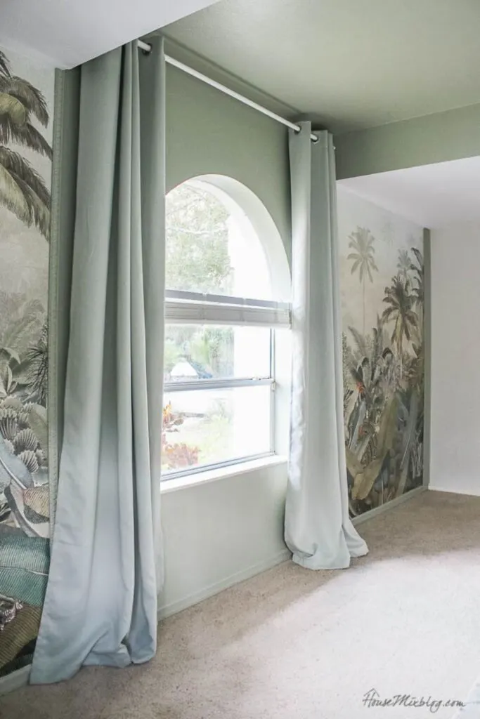 A playroom with a mural of a jungle and the walls around painted Sage Wisdom.