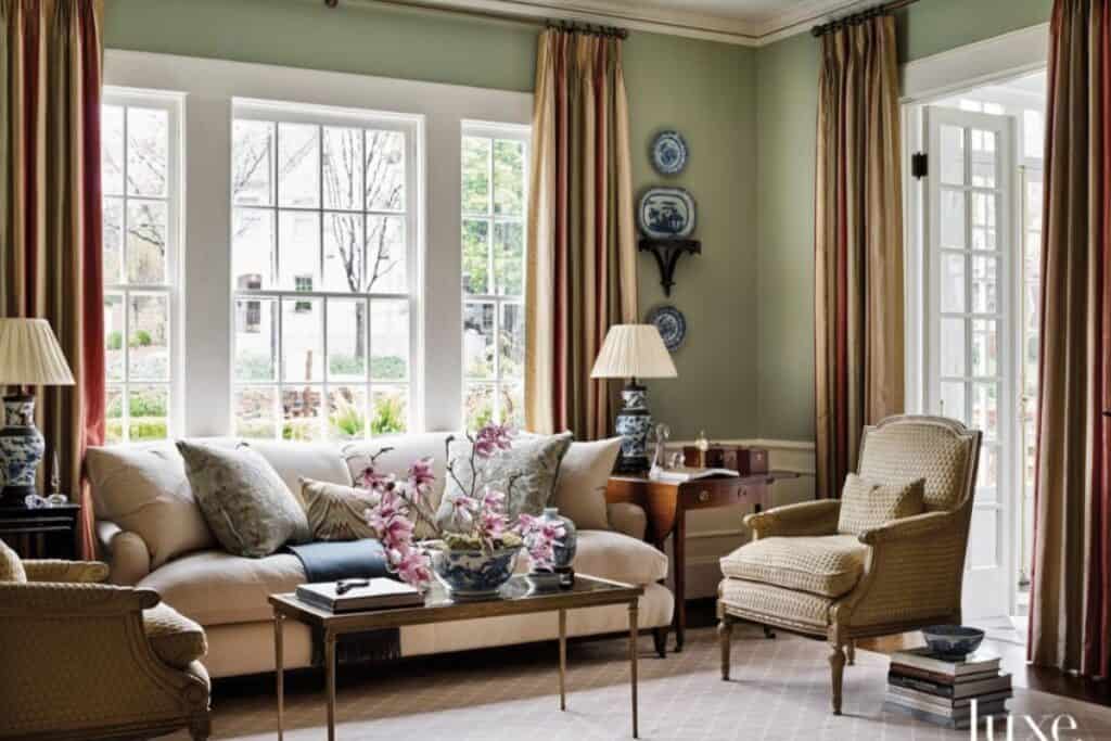 A living room with Saybrook Sge on the walls, striped curtains and neutral furniture.