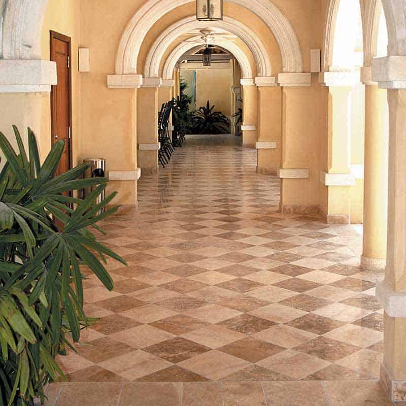 Brown and white checkered floors with a hallway full of arches and textured walls.