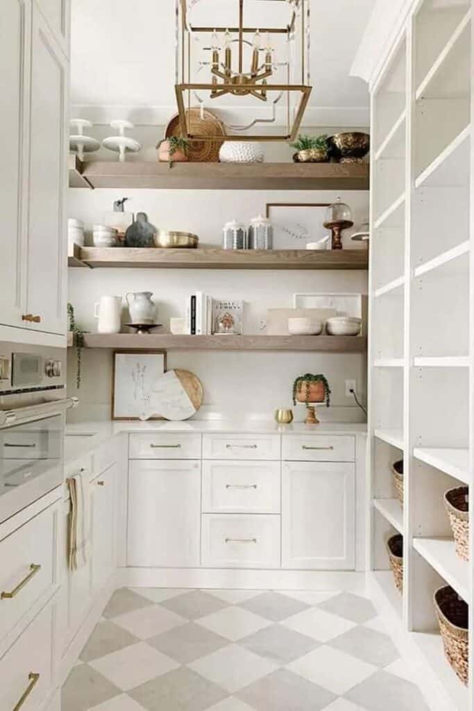 A butlers pantry with white cabinets, white counters and a checkered floor in white and light gray.