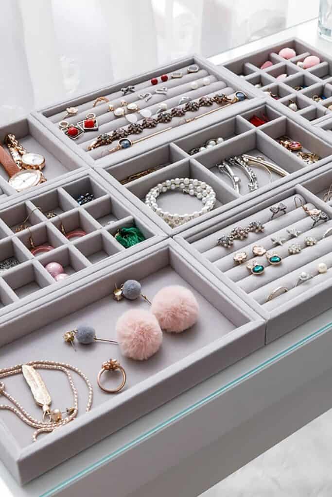 A large light gray jewelry box with different compartments to store different sized jewelry.
