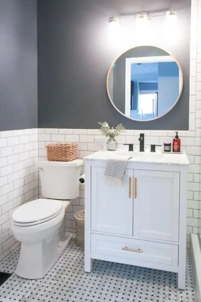 A bathroom with a white cabinet, white subway tile as wainscoting and Peppercorn painted on the walls above.