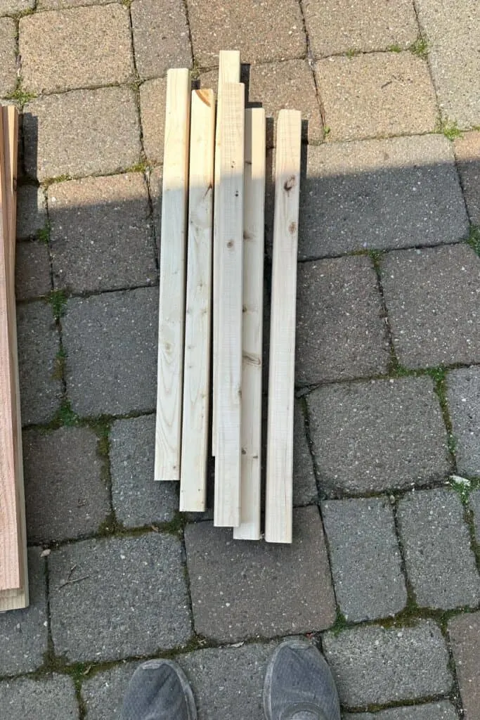 The brackets of the raised garden bed are cut and laying on my paver driveway.